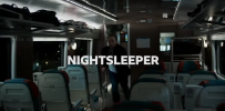 Still from Nightsleeper tv show (2024).  Character running through seated carriage.