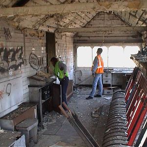 2003 March, inside the box with the architect prior to any works taking place. All 144 windows were broken and the floor and lever frame are covered w