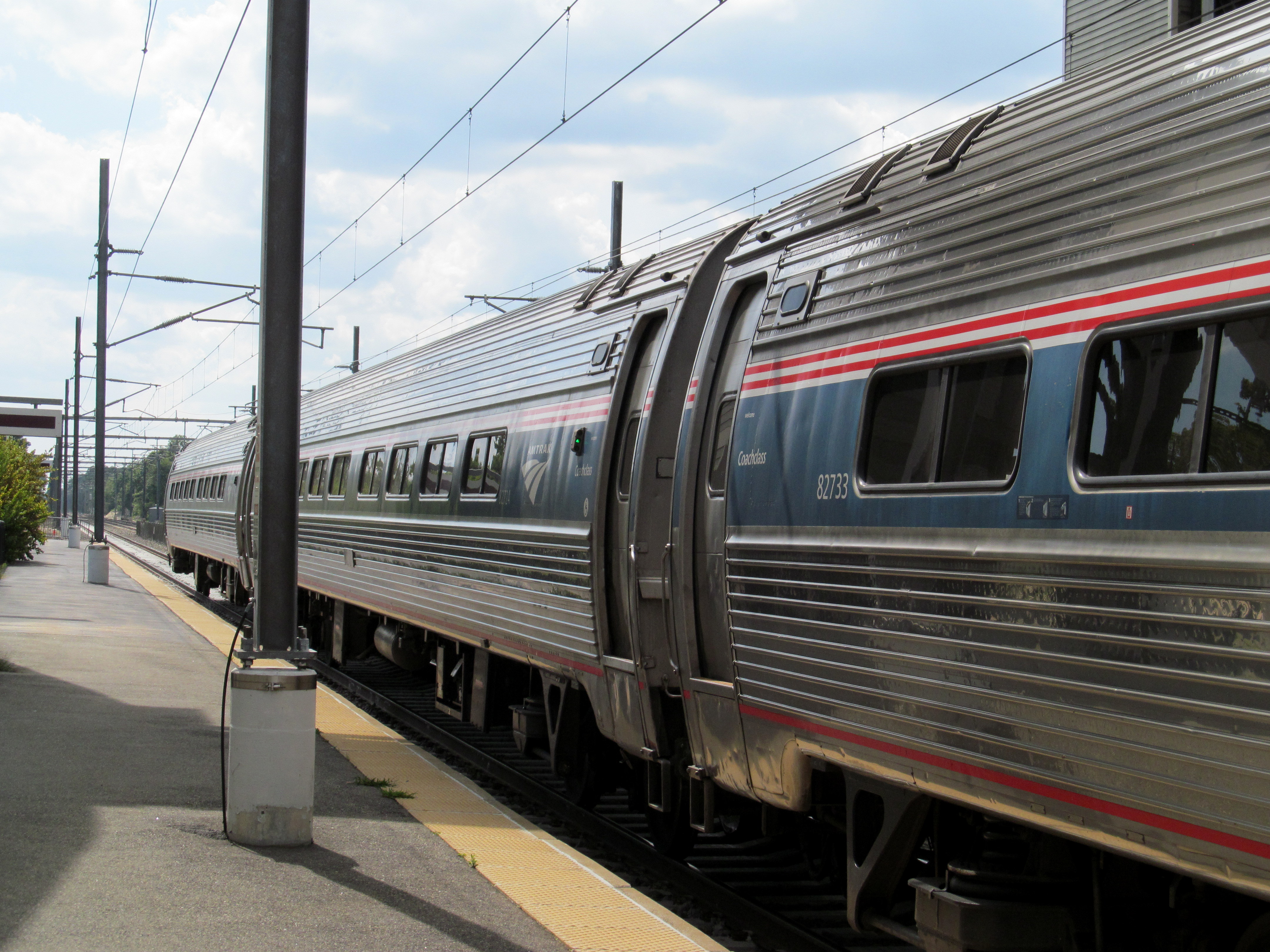 Corrugated silver tubular rail cars with red, white, and blue striping