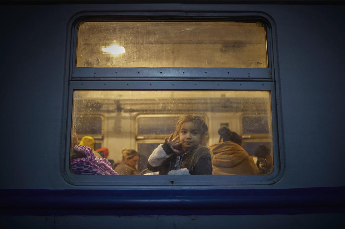 A girl looks out from a train evacuating her and her family from Lviv railway station to Poland