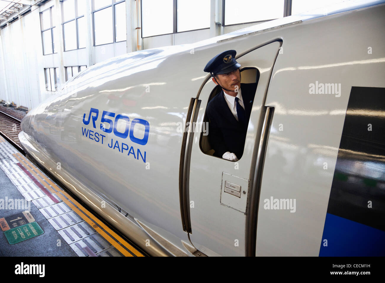 train-conductor-leaning-out-of-window-of-bullet-train-shinkansen-japan-CECM1H.jpg