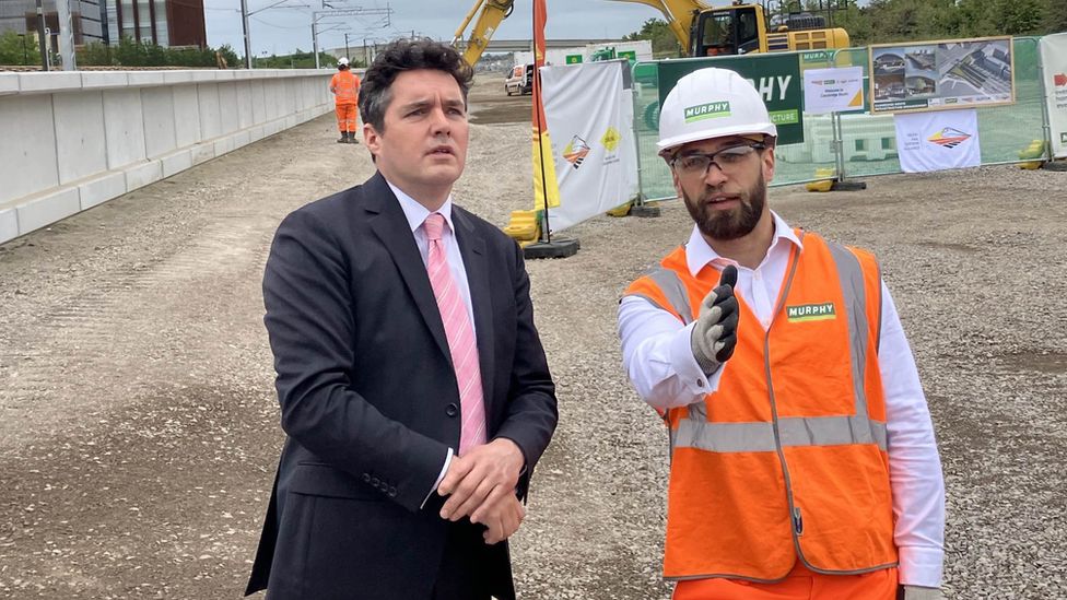 Rail minister Huw Merriman with a construction worker during his visit to the site where the station is being built