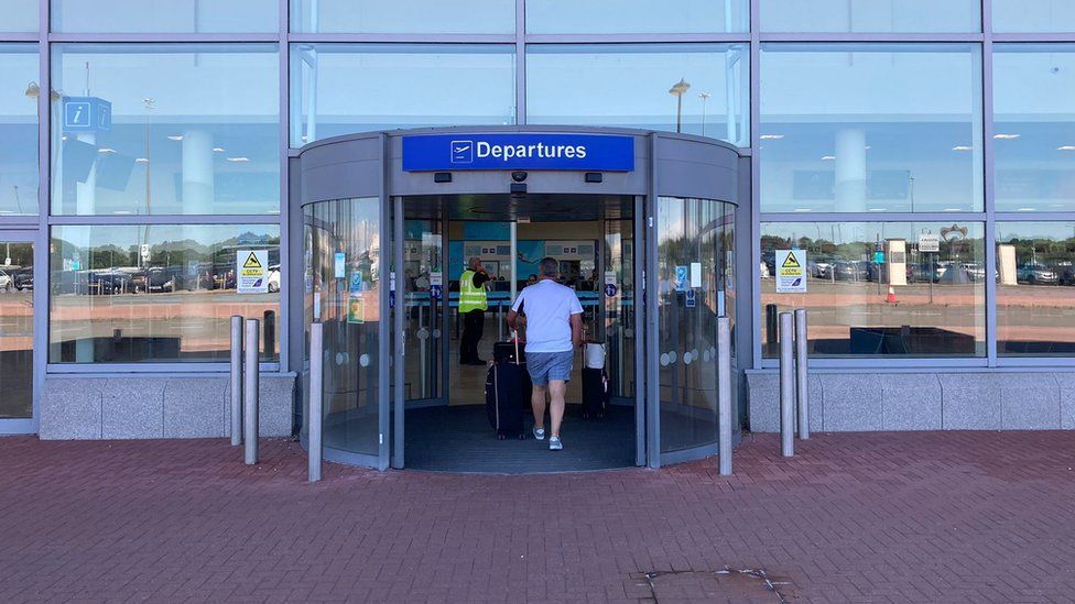 A man walking through the departures door at Doncaster Sheffield Airport